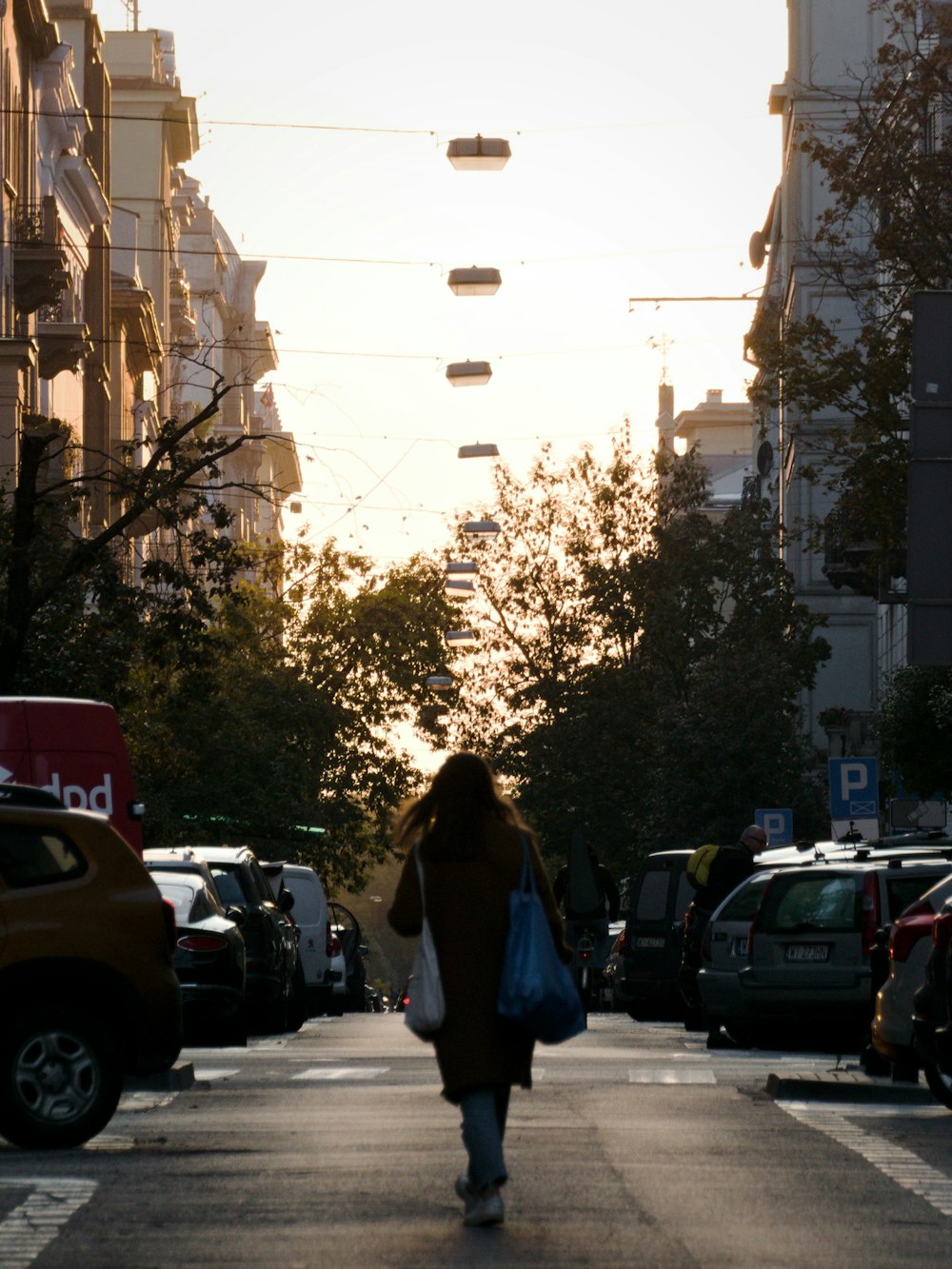 woman in black jacket standing on sidewalk during daytime