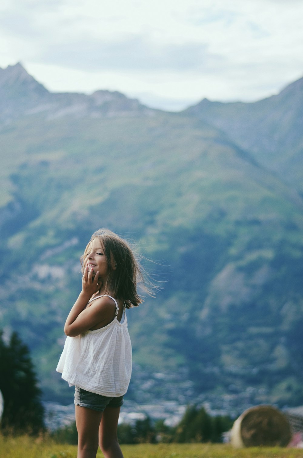 Mujer en vestido blanco de pie en la cima de la montaña durante el día