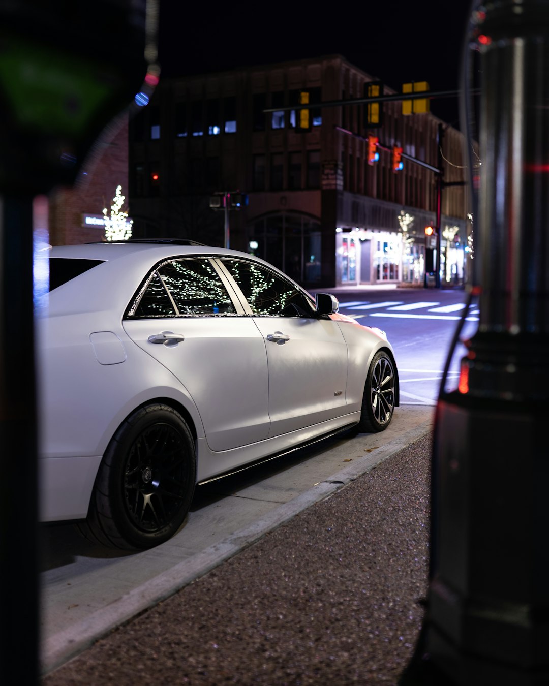 white coupe parked on sidewalk during night time