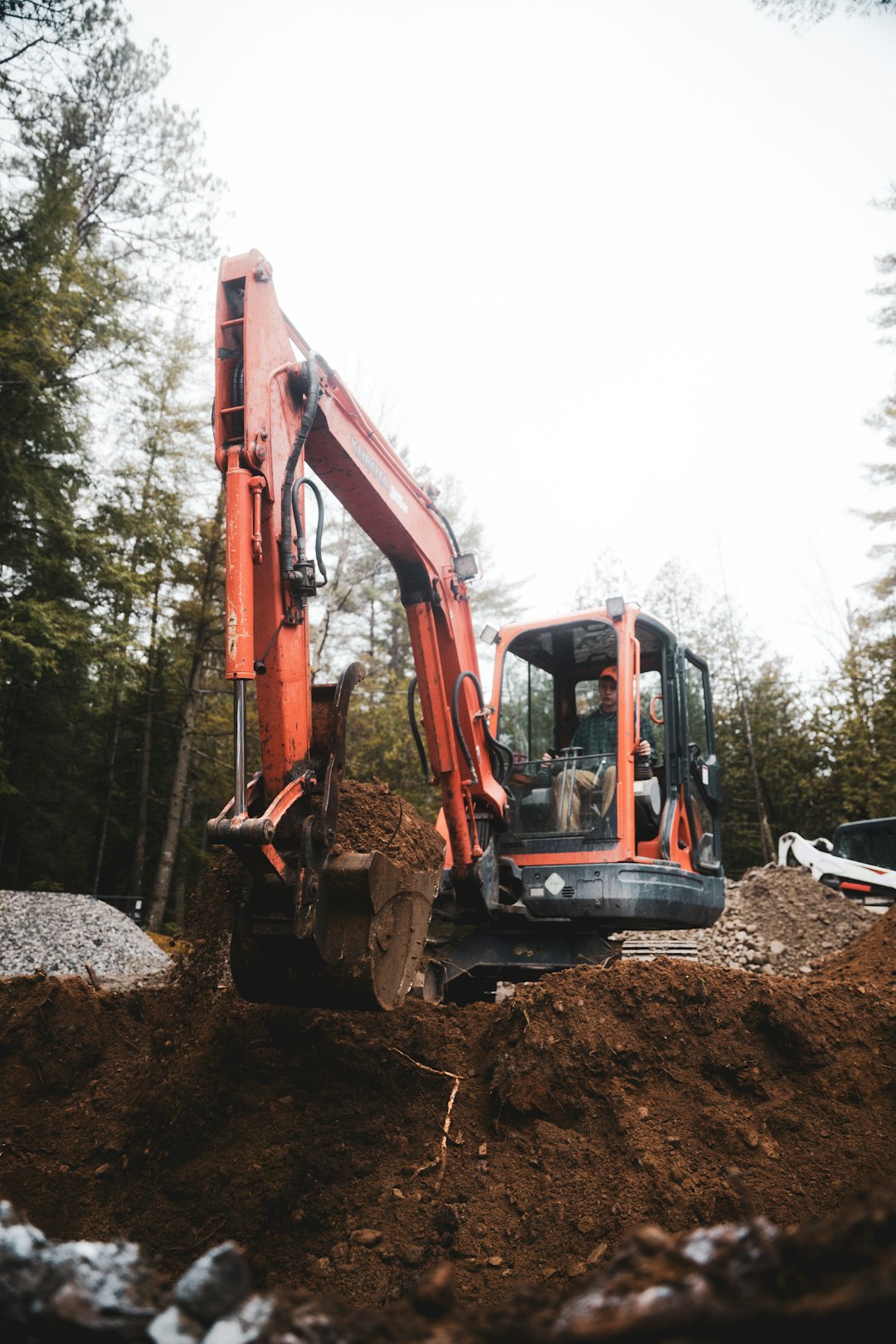 red and black excavator on rocky ground during daytime