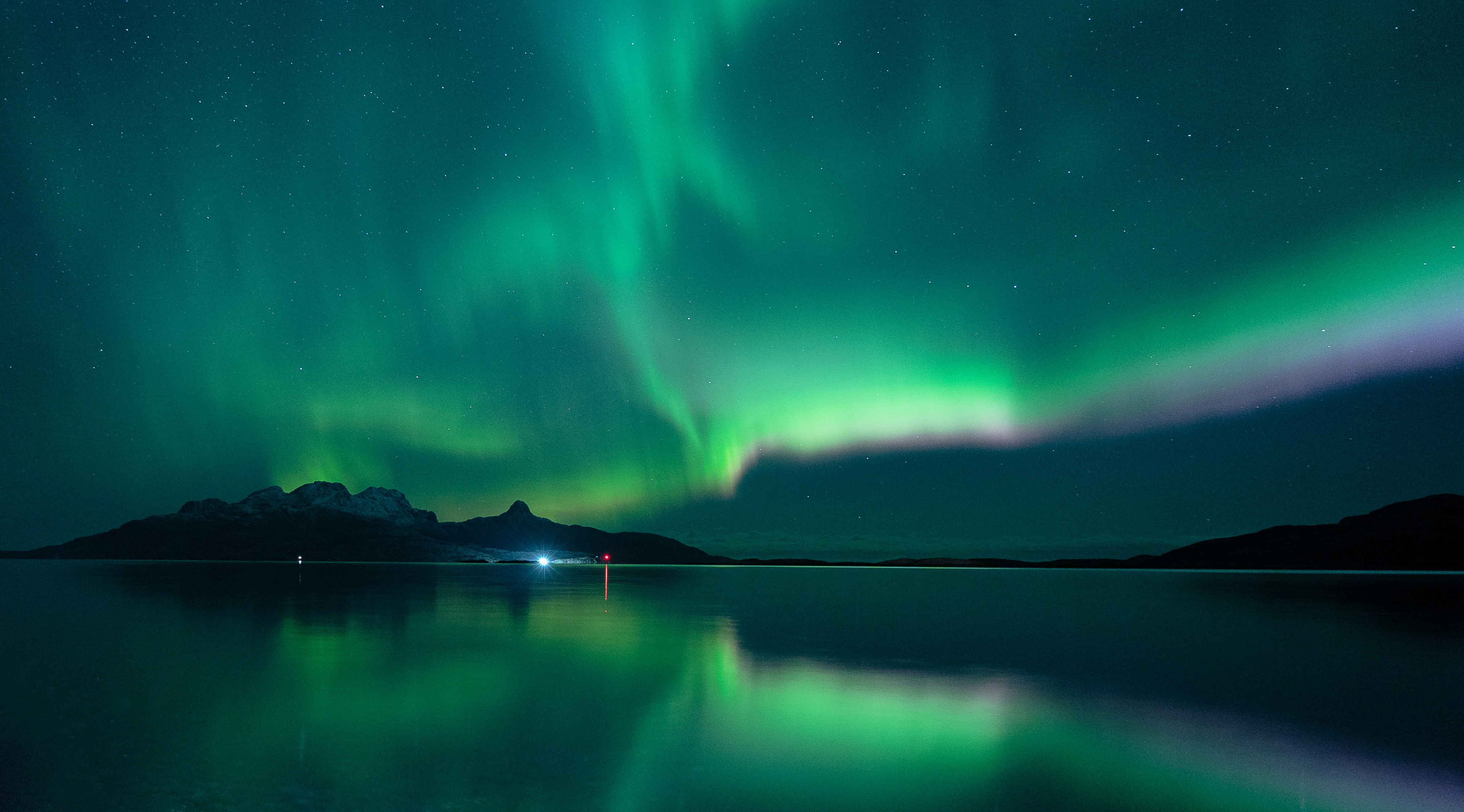 green aurora lights over lake