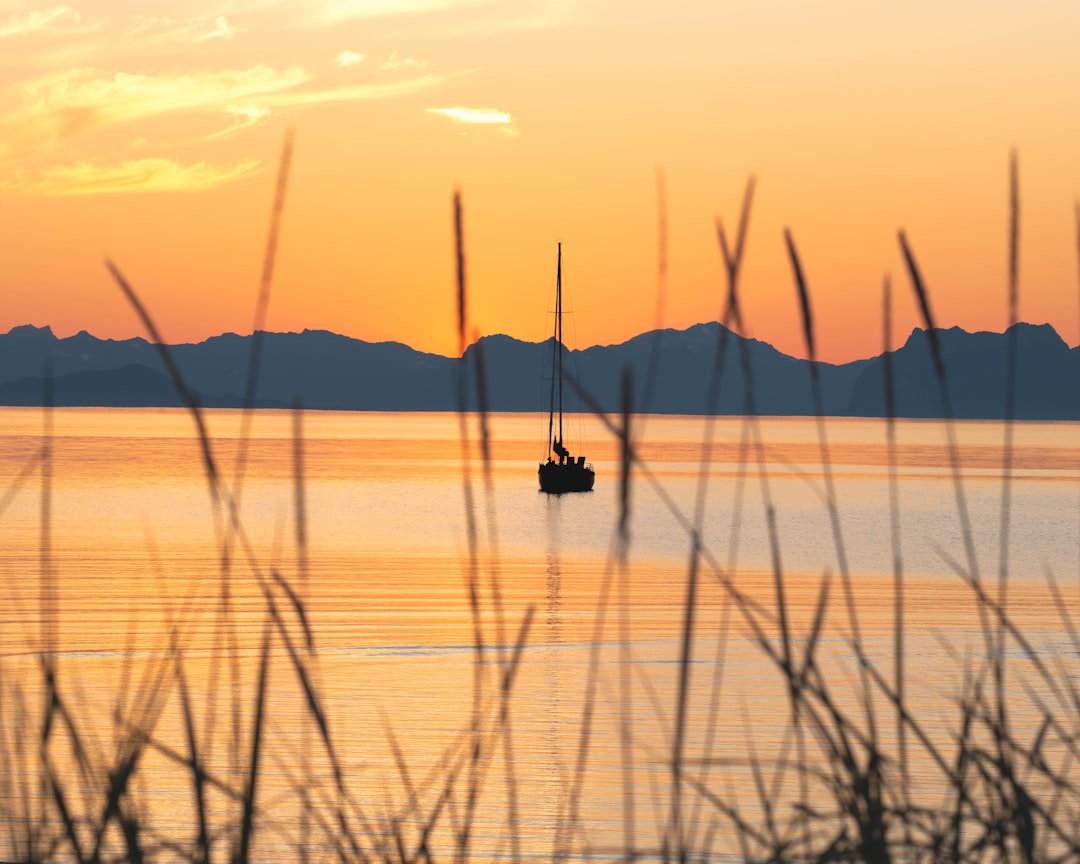 silhouette of boat on sea during sunset