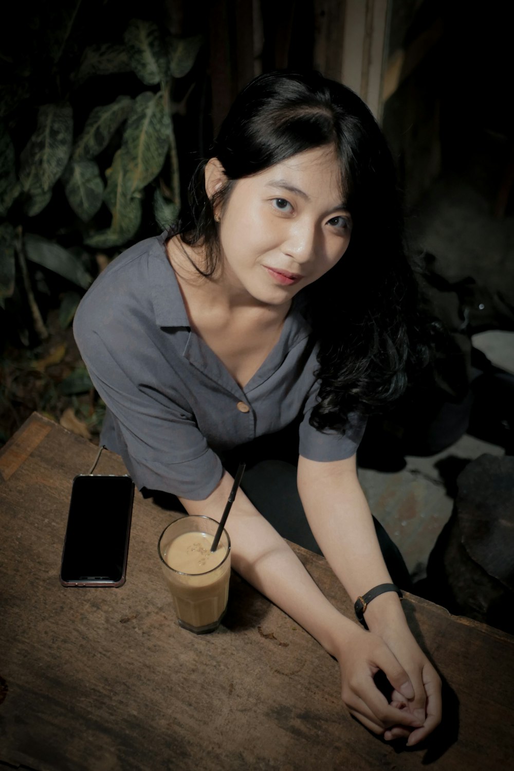 woman in gray button up shirt sitting on brown wooden bench