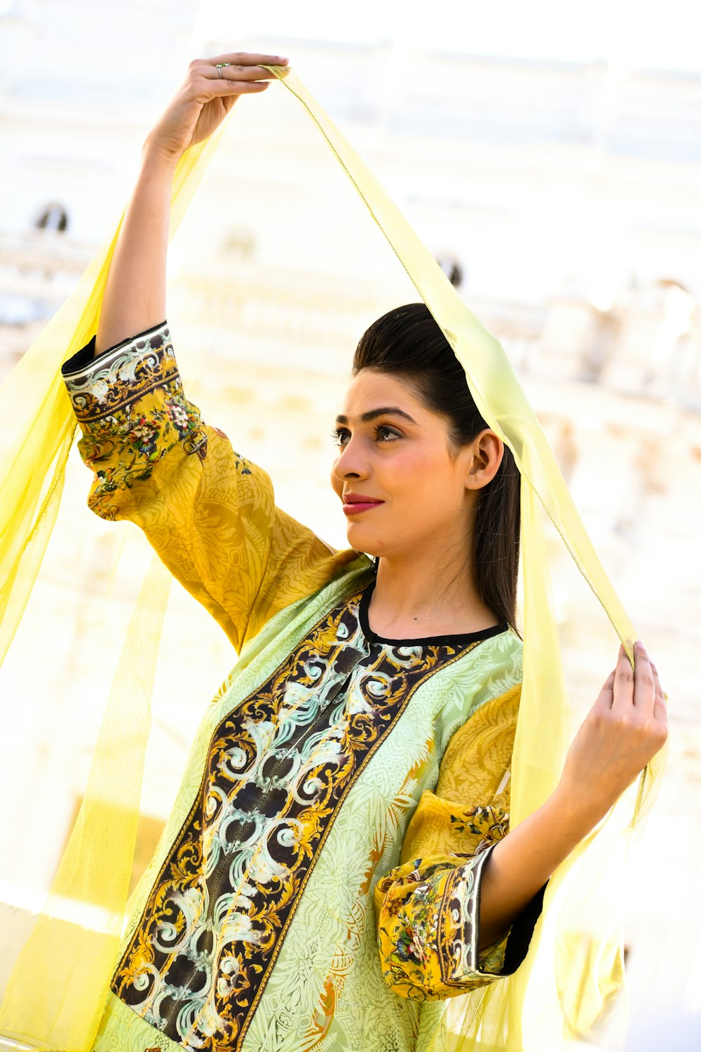 woman in yellow and blue floral dress holding her head