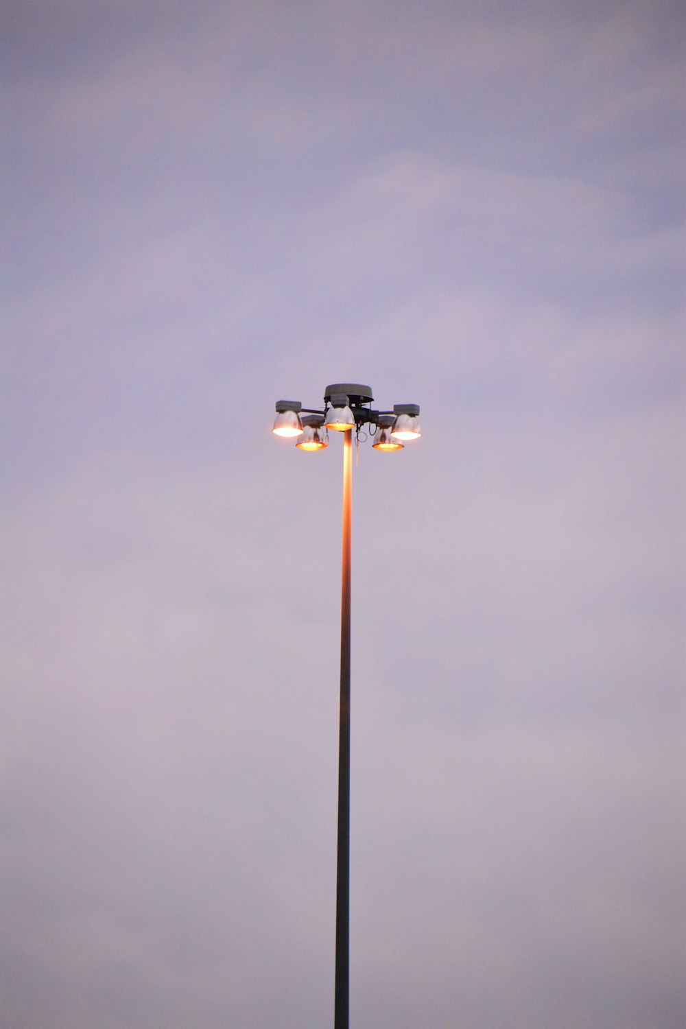 luz de rua preta e branca sob o céu cinzento