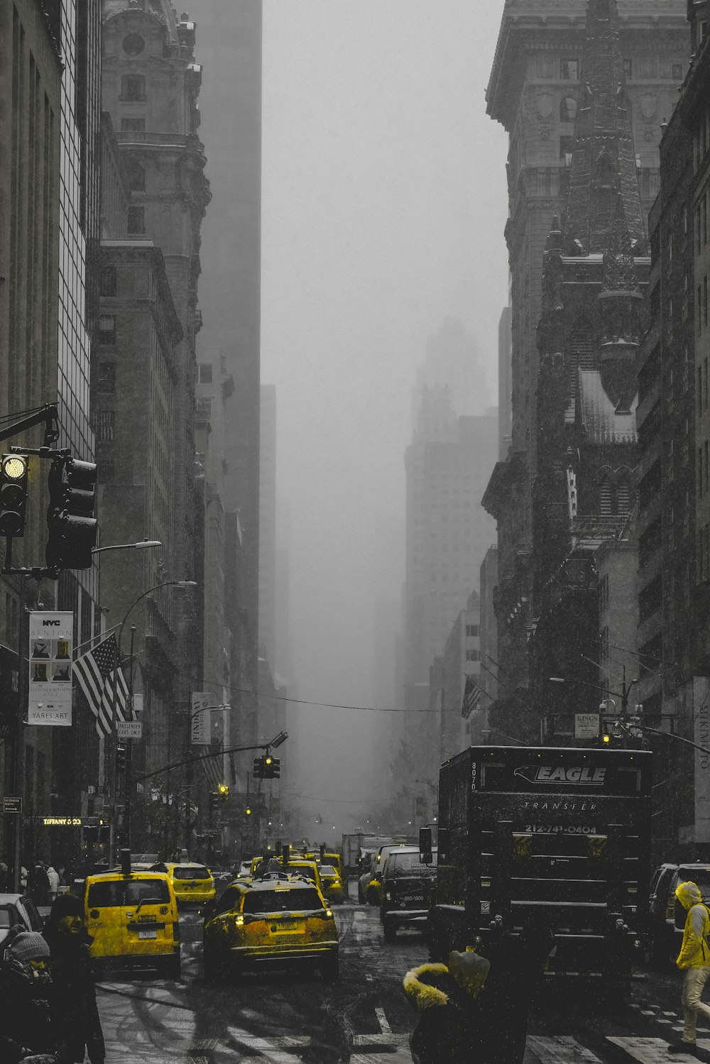 cars on road between high rise buildings during daytime