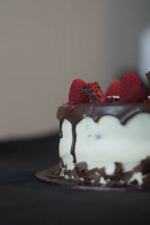 A tempting chocolate cake with glossy ganache and fresh berries on top.