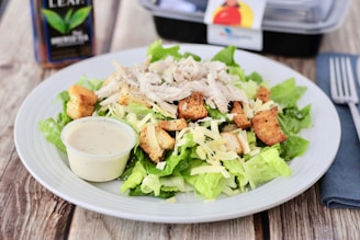 A colorful plate featuring a fresh Caesar salad with crisp lettuce, croutons, and grated cheese.