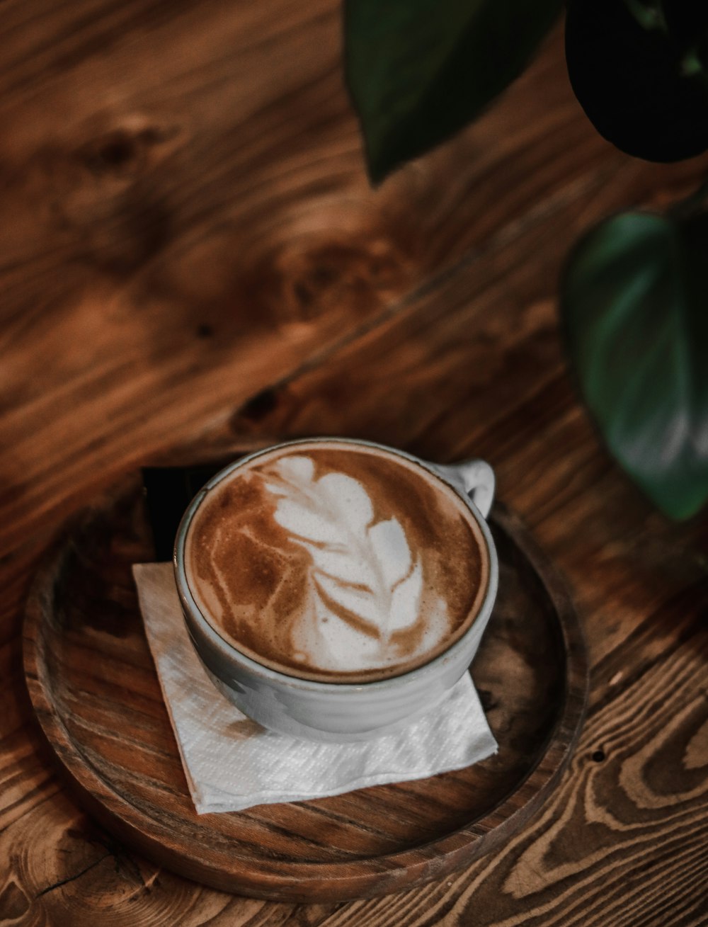 weiße Keramiktasse mit Kaffee auf braunem Holztisch