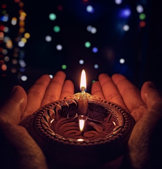 lighted candle on brown round holder