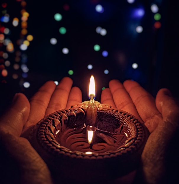 lighted candle on brown round holder