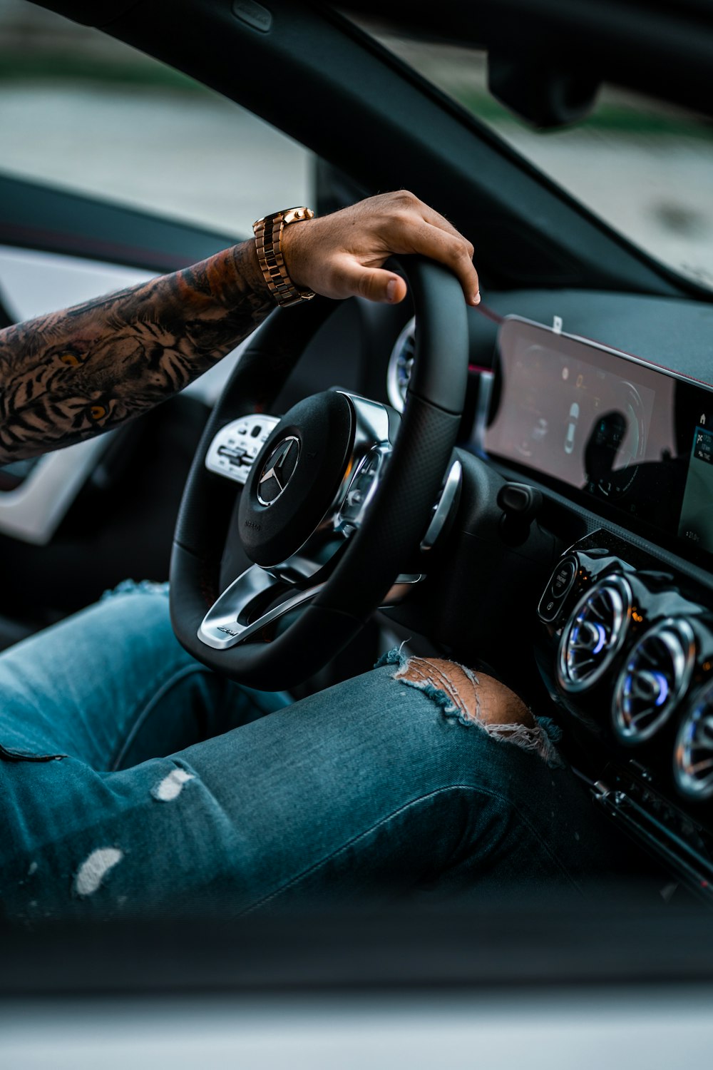 person in blue denim jeans driving car