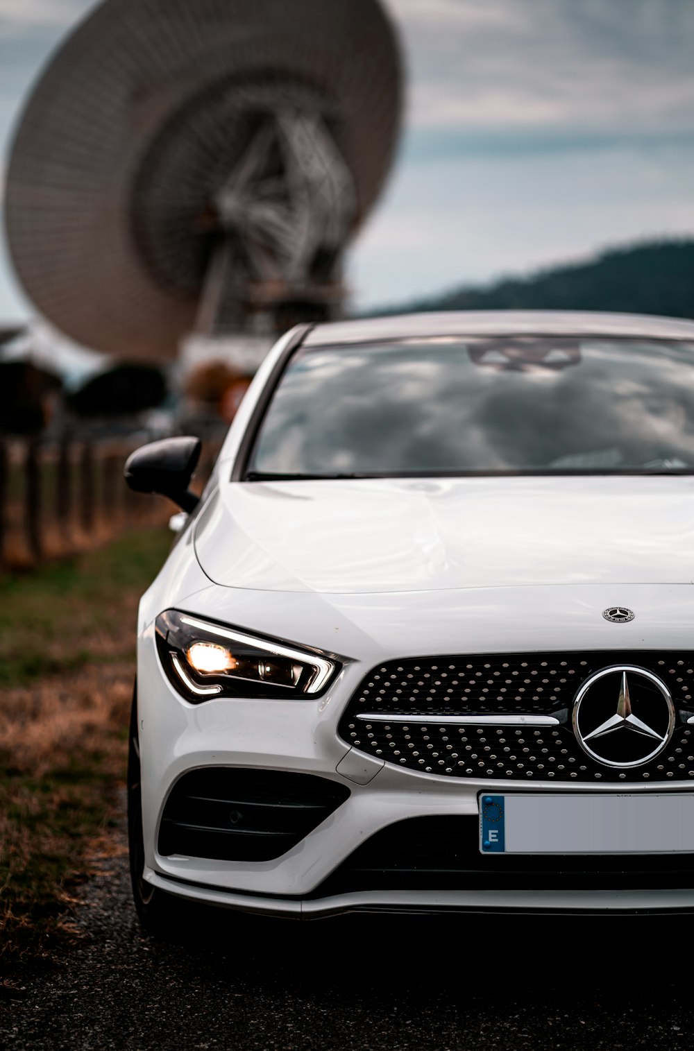 white mercedes benz car on green grass field during daytime