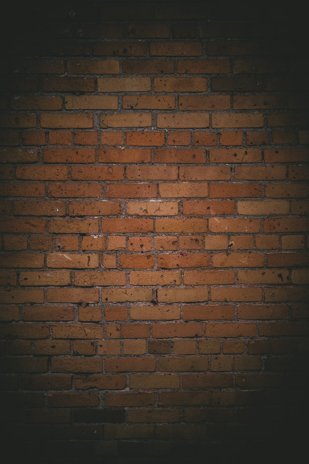 Pared de ladrillo marrón durante la noche