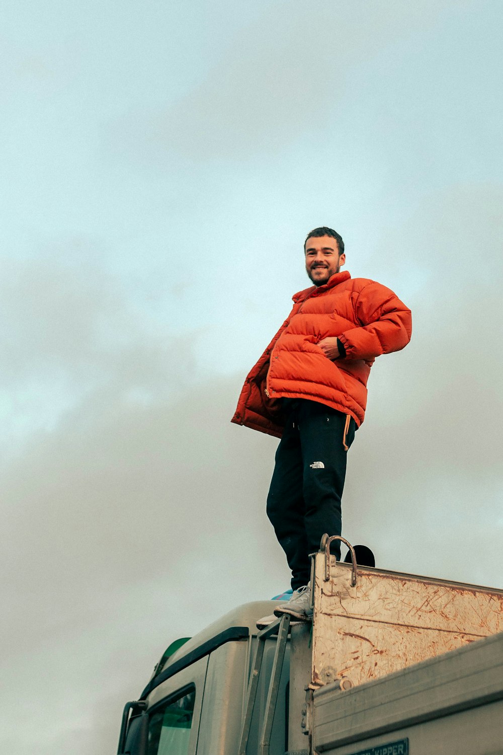 man in red hoodie standing on top of building