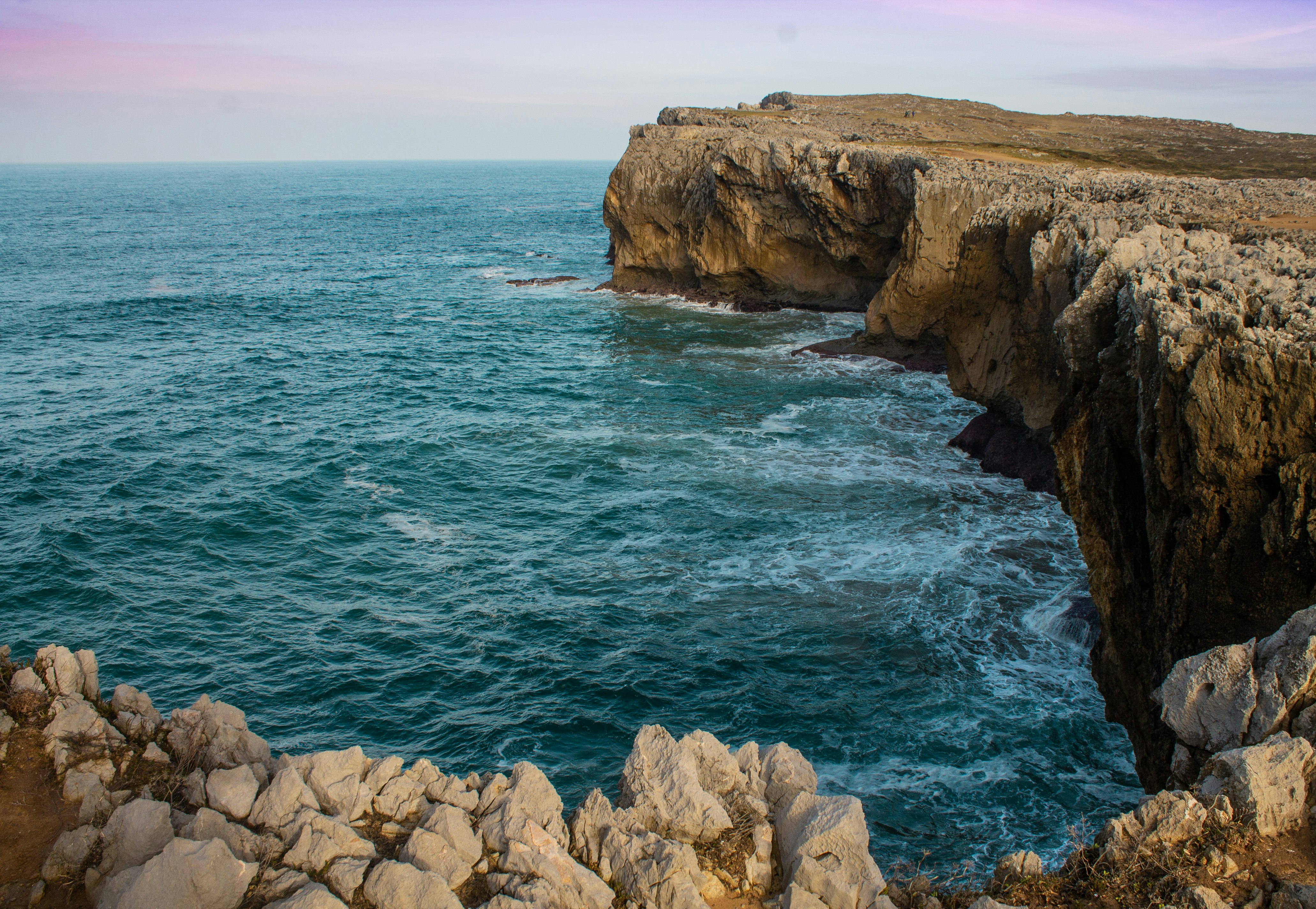 brown rock formation beside blue sea during daytime