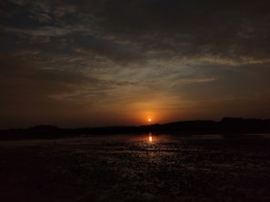 A serene landscape with a sunset casting warm hues.