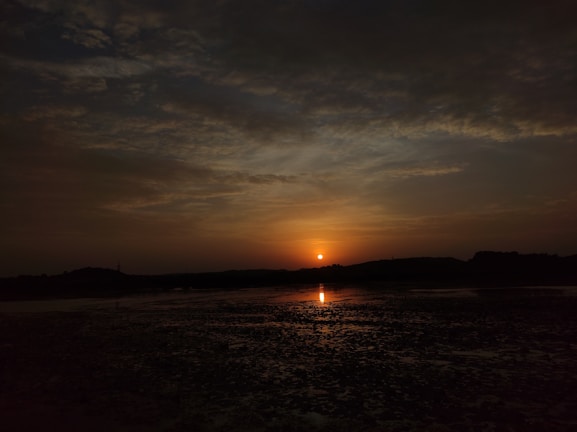 A serene landscape at sunset with warm, glowing colors.