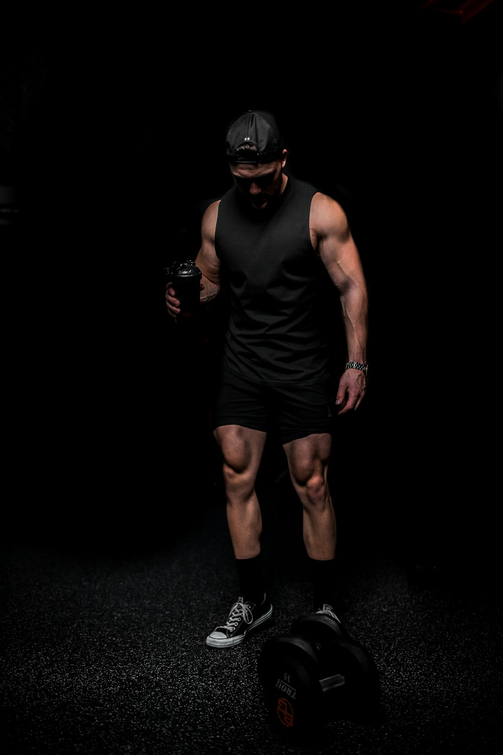 man in black tank top and shorts wearing black mask