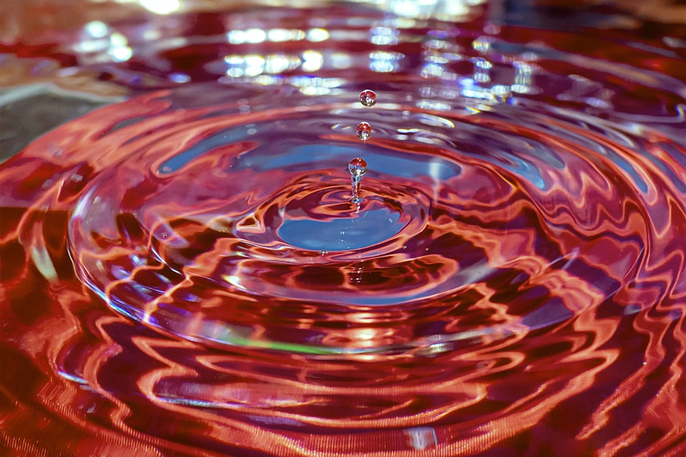 goccia d'acqua su superficie rossa