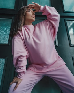 A model posing in a neon pink oversized sweatshirt with the Positive Vibes Threads logo, set against a clean white background
