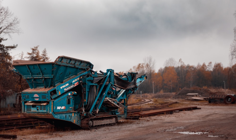 green and black heavy equipment on brown dirt road during daytime