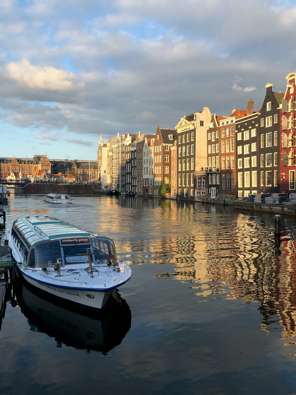 white and blue boat on water near city buildings during daytime