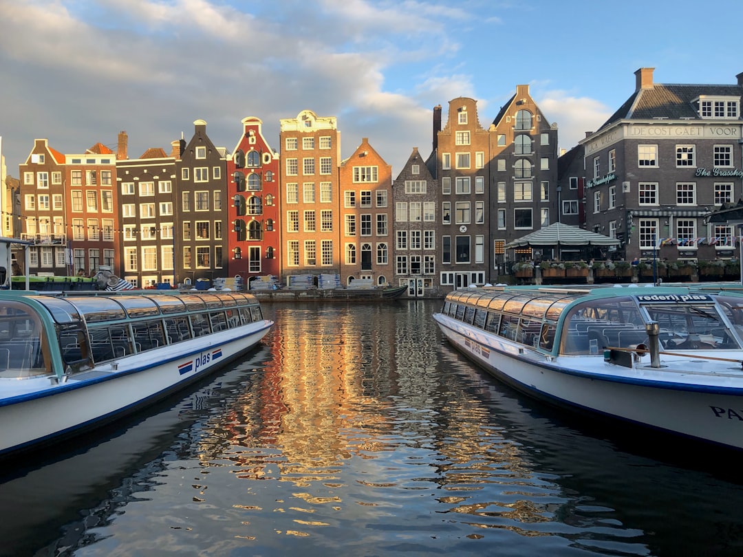 white and blue boat on water near buildings during daytime