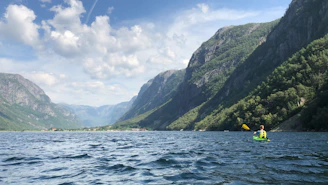 green mountain beside body of water during daytime
