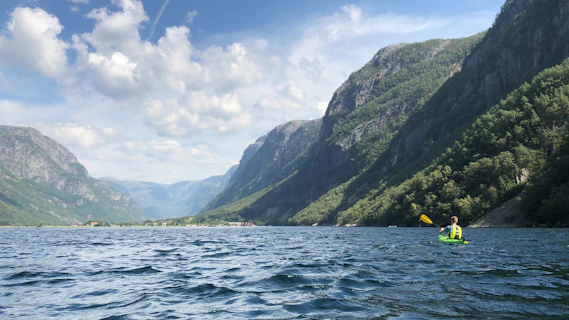 green mountain beside body of water during daytime