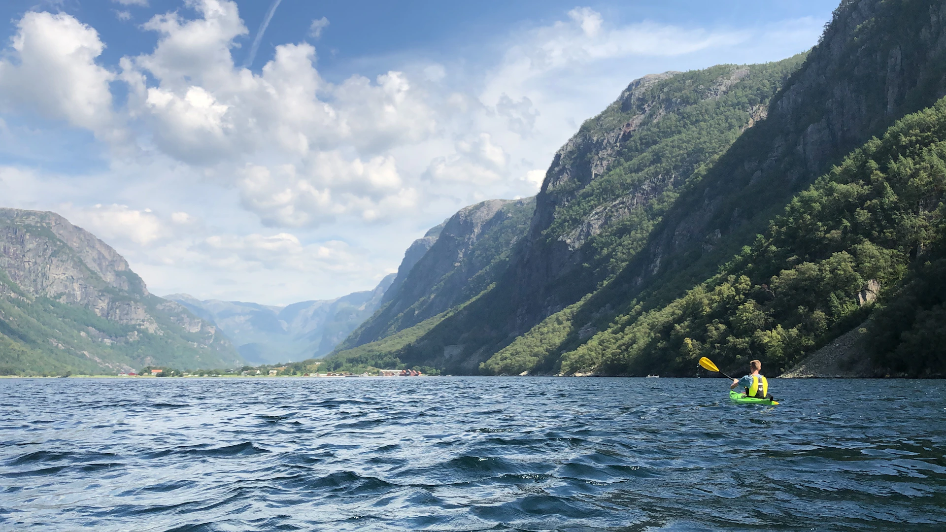 green mountain beside body of water during daytime