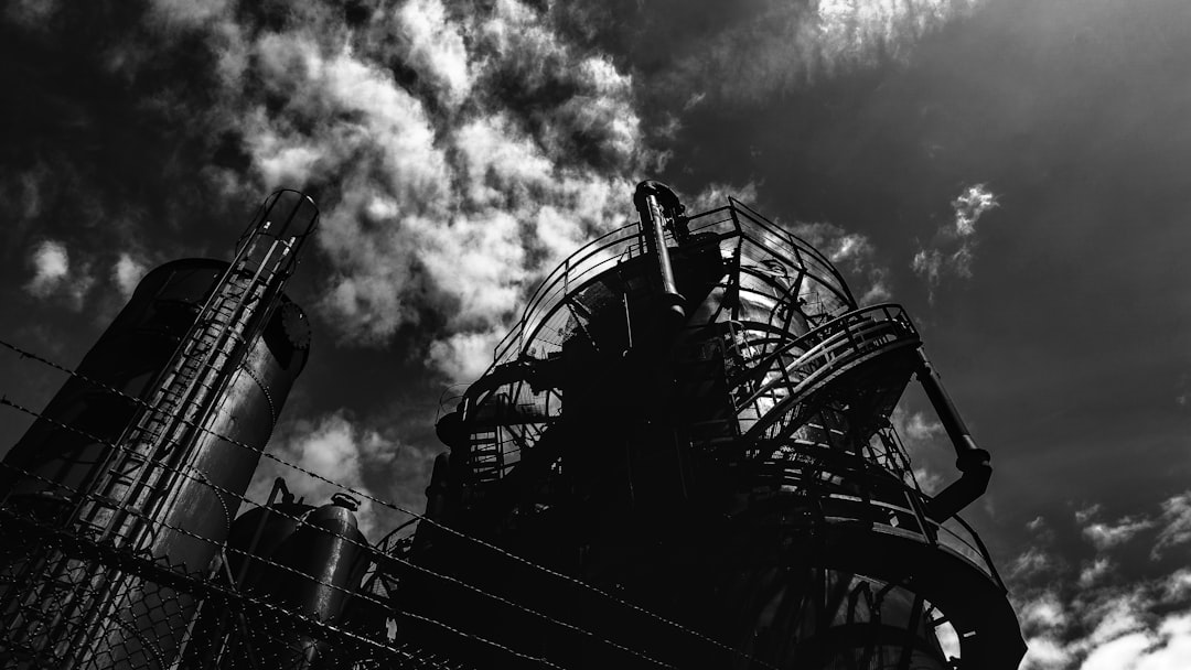 grayscale photo of ferris wheel under cloudy sky