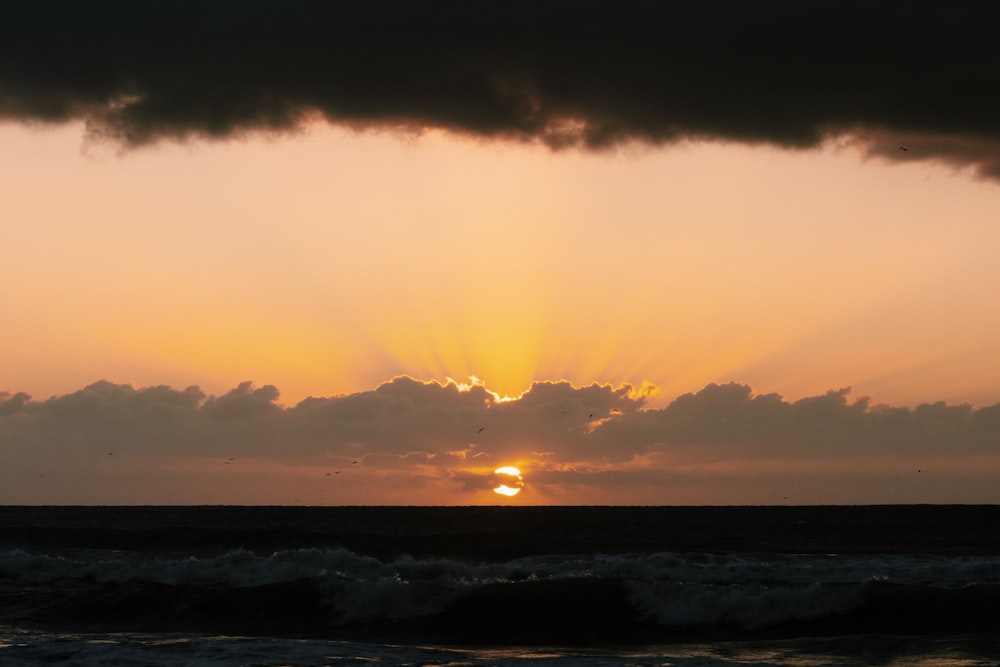 ocean waves crashing on shore during sunset