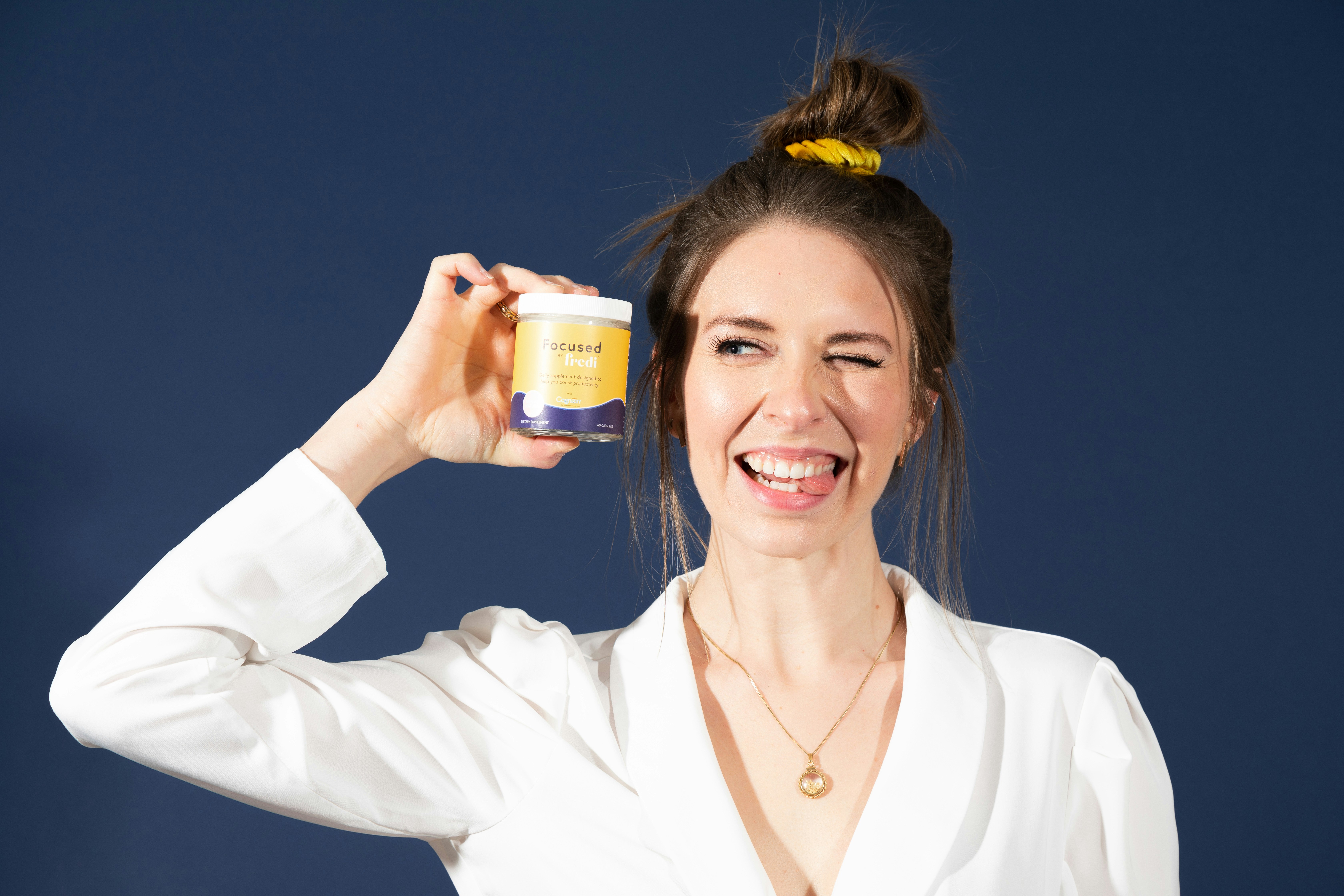 白いプラスチックボトルを保持している白いブレザーの女性