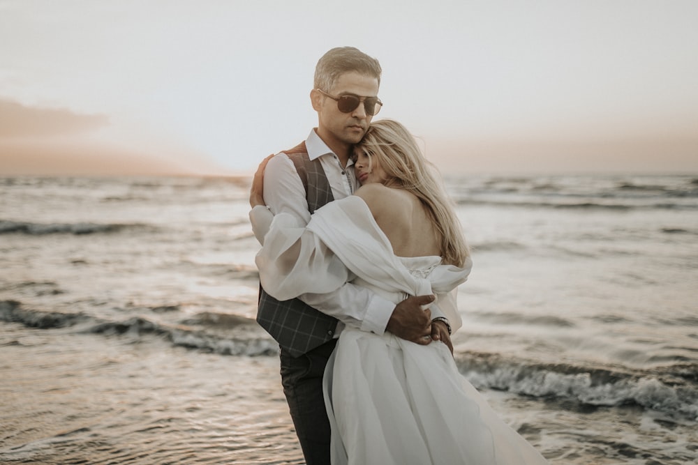 man and woman standing on beach during daytime