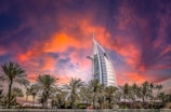 The sail-shaped Burj Al Arab glowing warmly at dusk.