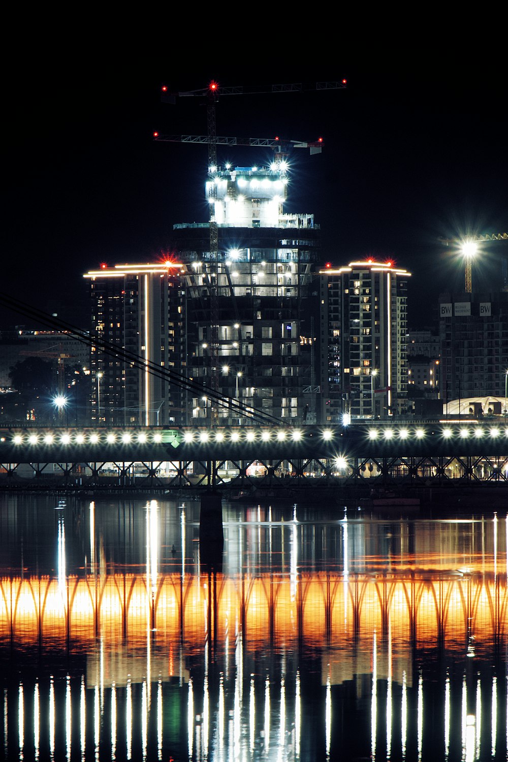 lighted bridge over water during night time