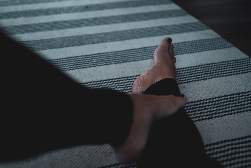 person in black pants on gray and white stripe textile