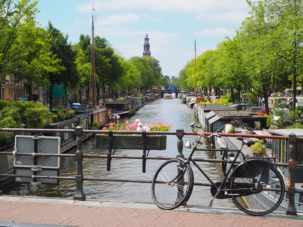 black city bike parked by a beautiful canal in Amsterdam
