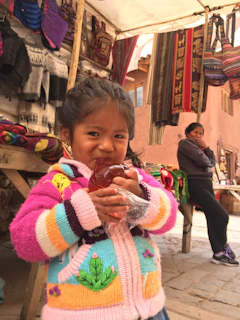 A young Wayuu girl proudly holding a freshly finished handwoven shoulder bag.