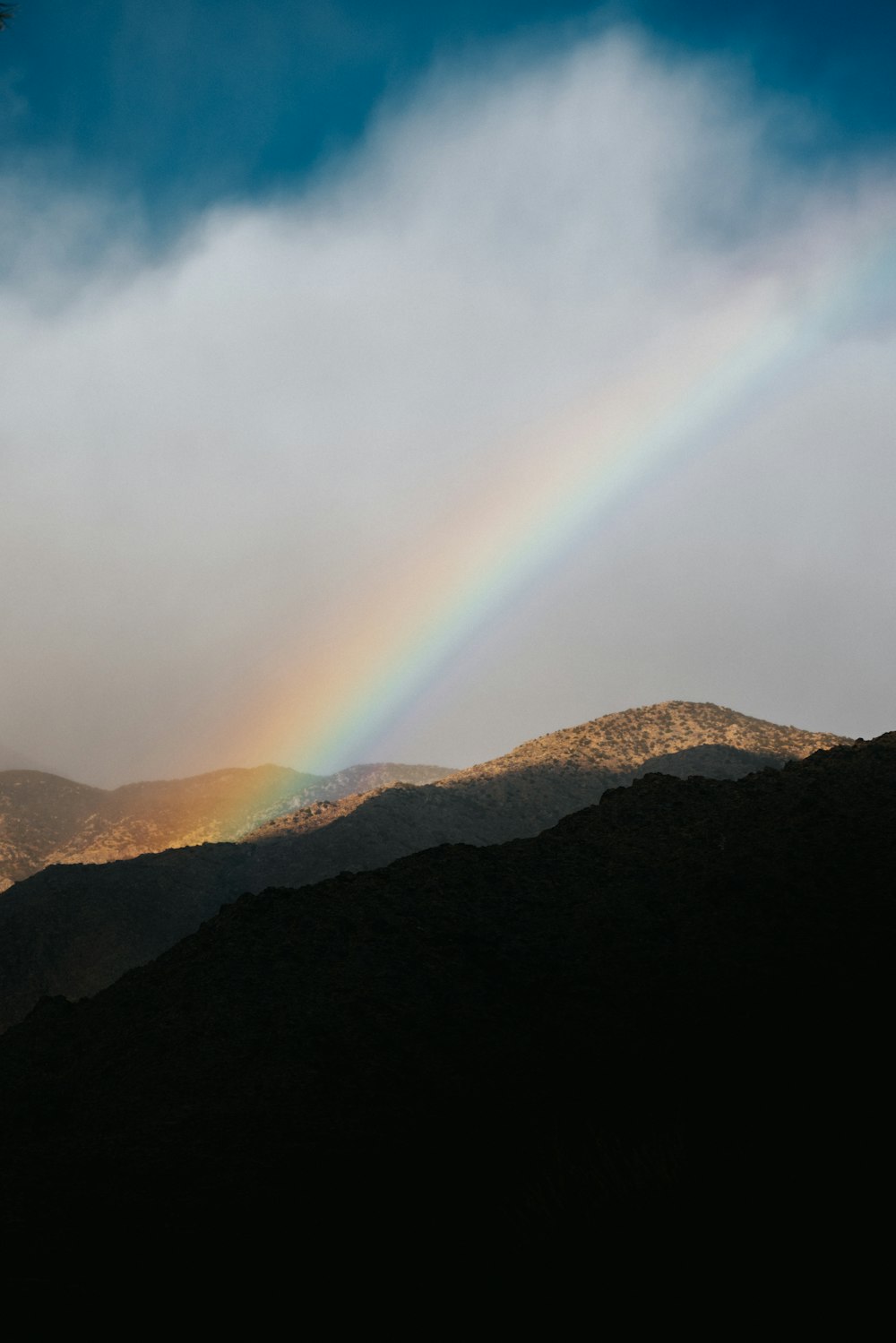 silhouette of mountain under white clouds during daytime