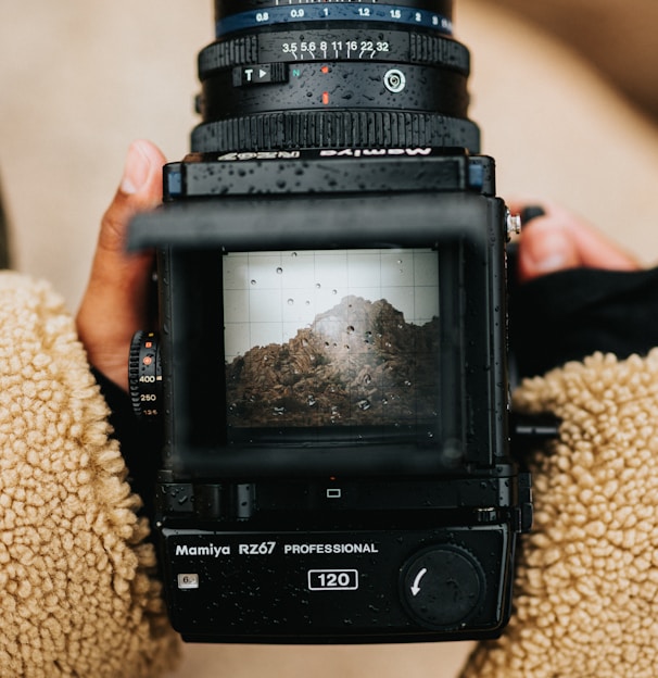 black dslr camera on brown textile