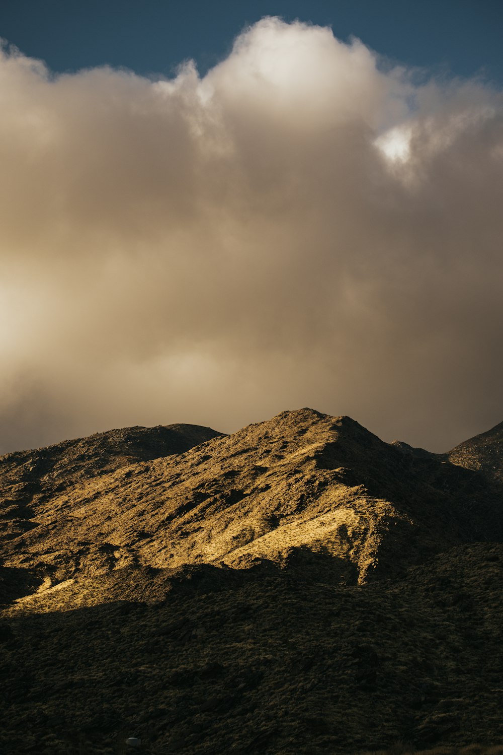 brown mountain under white clouds