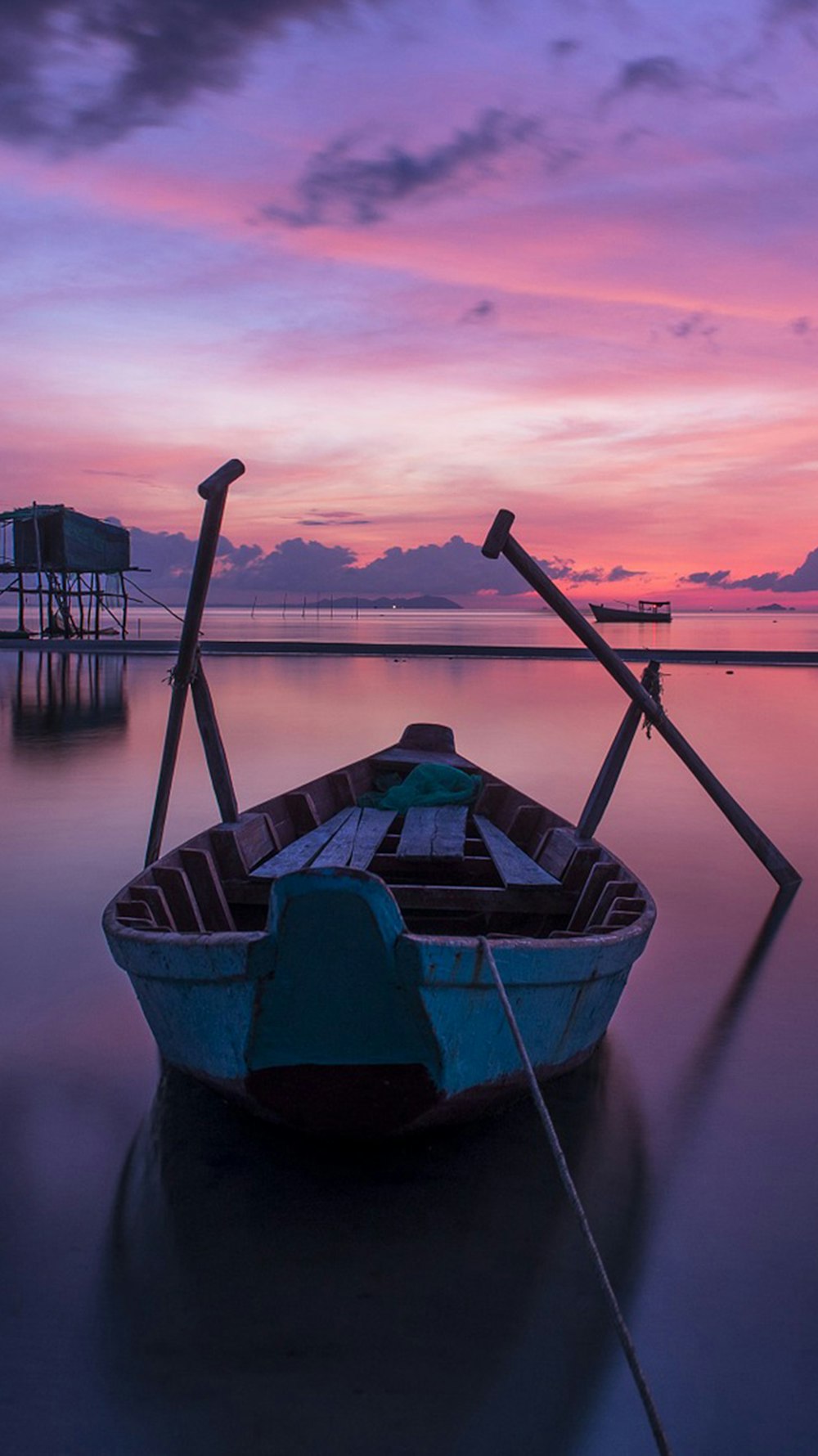 blue boat on body of water during sunset