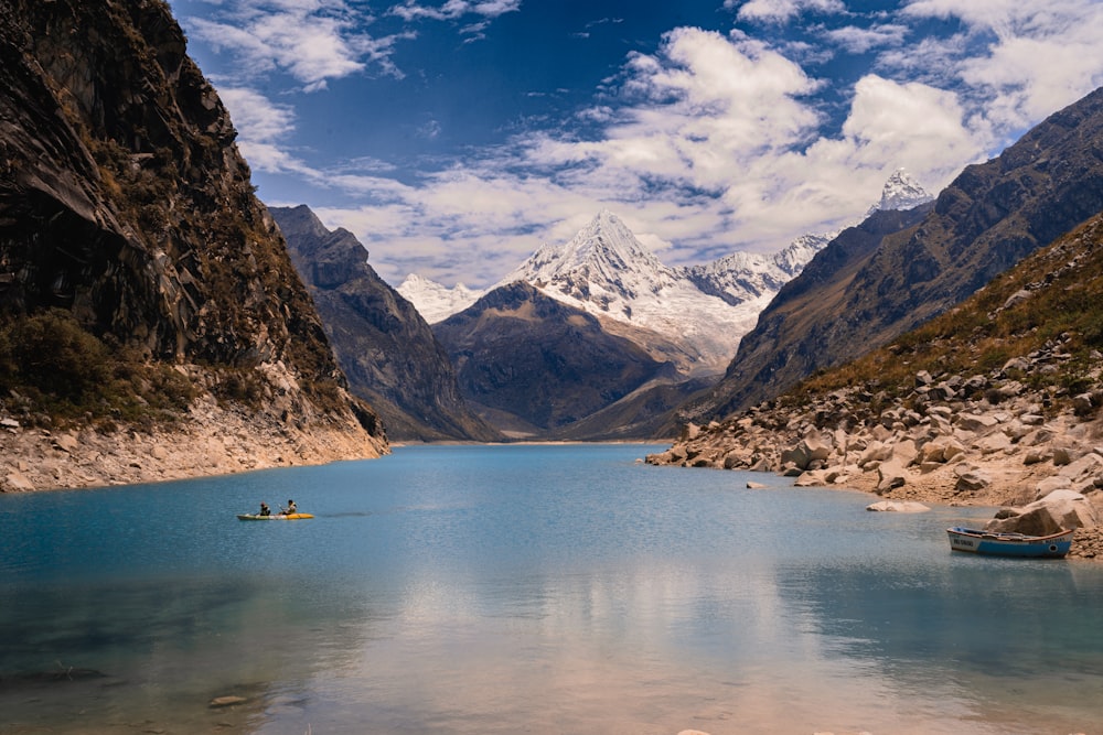 body of water near snow covered mountain during daytime