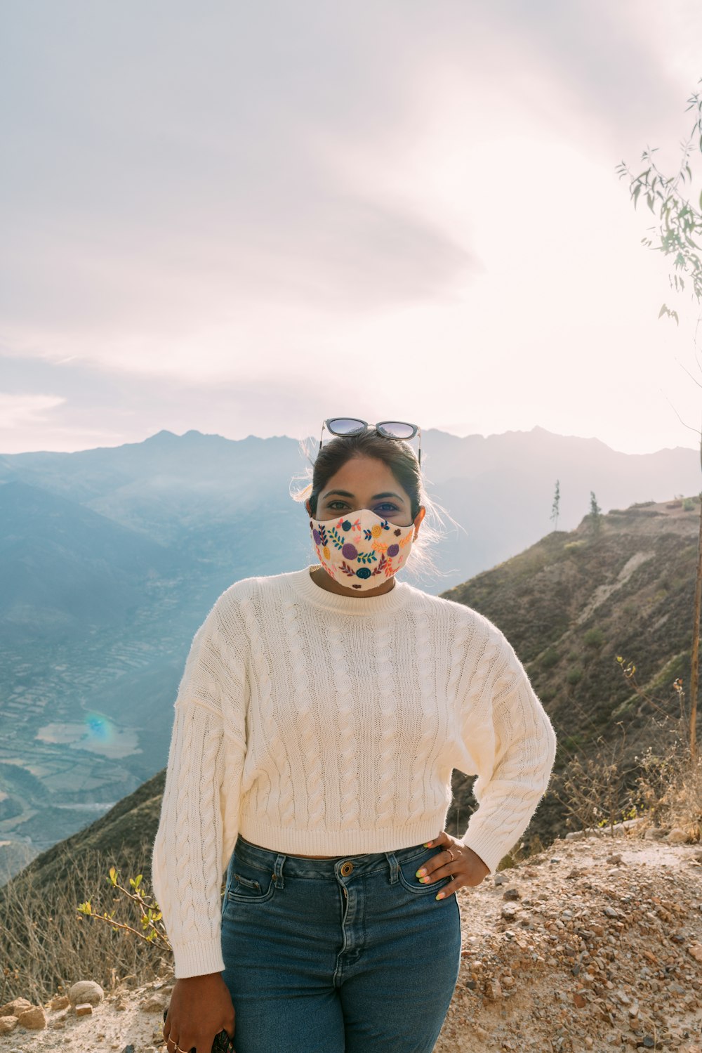 man in white sweater standing on mountain during daytime