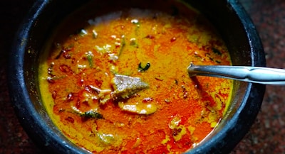 Vibrant bowls of Indian curry with rich spices and colorful garnishes, steaming hot.