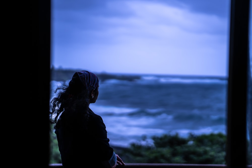 woman in black jacket standing near body of water during daytime