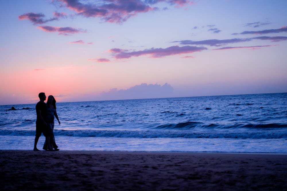 woman in black dress standing on beach during sunset