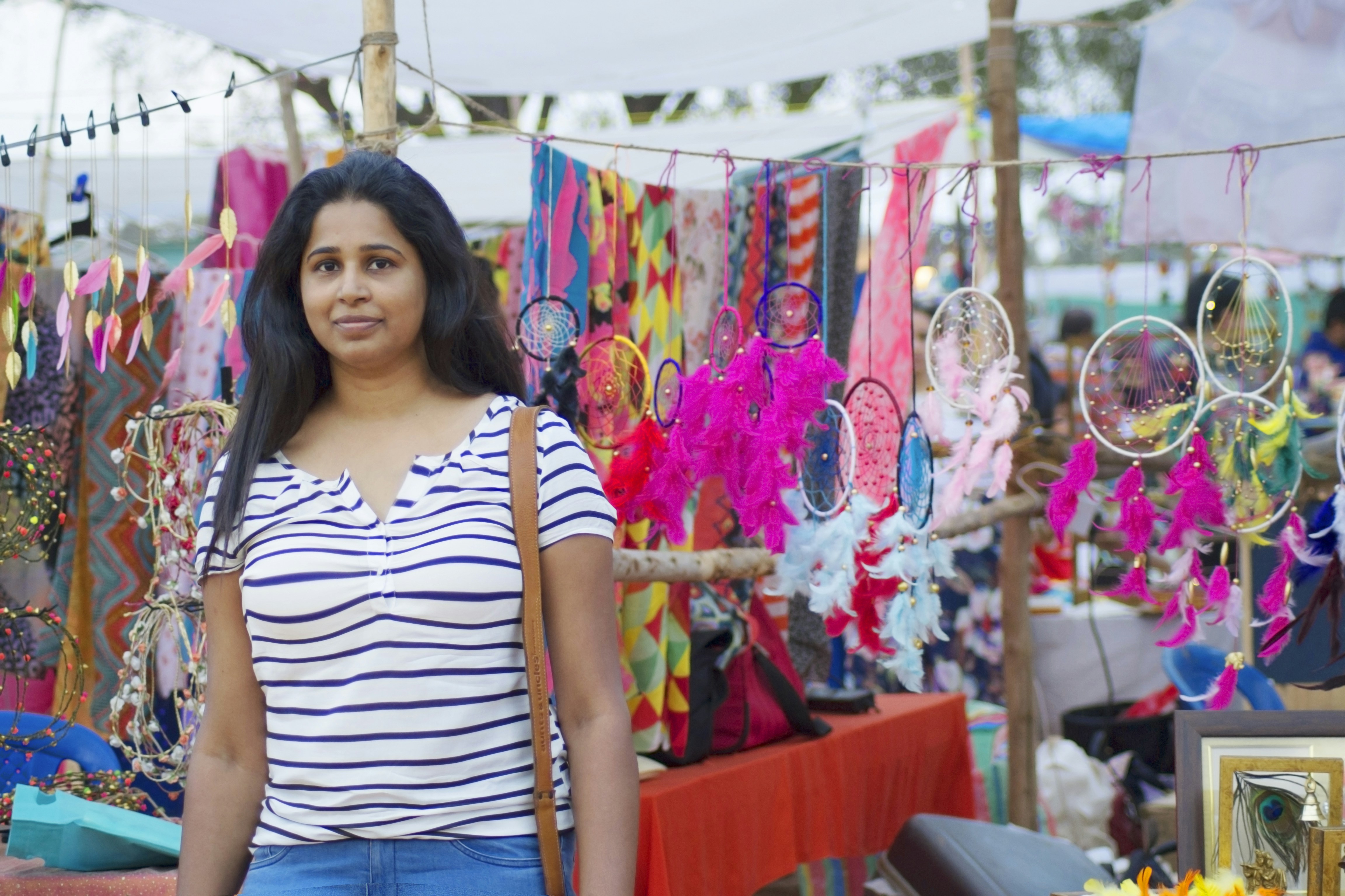 woman in white and black striped shirt standing near graffiti wall